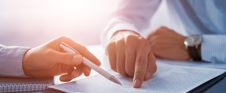 Business people negotiating a contract. Human hands working with documents at desk and signing contract.