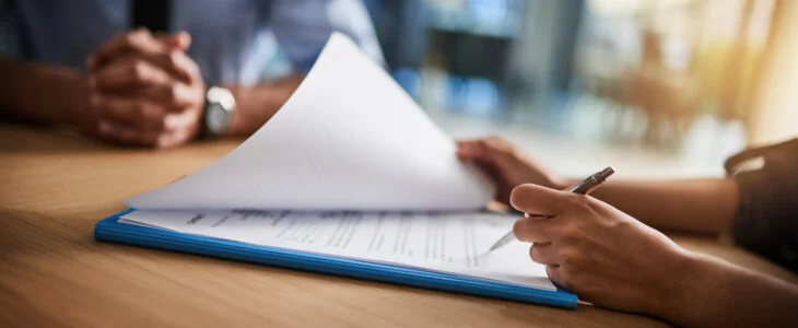 Cropped shot of a man and woman completing paperwork together at a desk