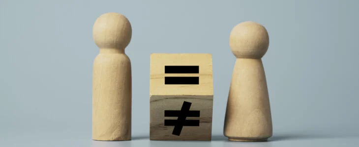 Flipping of unequal to equal sign between man and woman wooden figure. Human and business right concept.